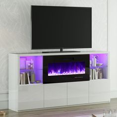 an entertainment center with a large television and purple flames on the wall behind it in a living room