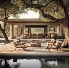 an outdoor living area with chairs and tables next to a pool in front of a house