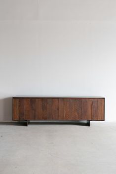 a large wooden cabinet sitting on top of a white floor in front of a wall