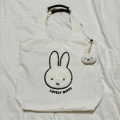 Selling This Rare Nwt Miffy Japan Kawaii Canvas Tote Bag! Brand New In Original Plastic Packaging. Purchased In Japan. Japan Import. Canvas Tote Bag With A Big Miffy Logo On The Front! Miffy Logo’s Edges Are Embroidered, And The Face Is Made Out Of A Sherpa Fabric Material. Super Soft To The Touch! Says “Lovely Miffy” On The Front. Also Includes A Removable Miffy Sherpa Plush Keychain. Tote Bag Has 1 Main Zip Compartment, 1 Exterior Small Zip Pocket, And 2 Small Pockets On The Inside. Measures 1 Miffy Items, Miffy Japan, Miffy Stuff, Miffy Bag, Aesthetic Wishlist, Japan Haul, Miffy Keychain, Japan Kawaii, Sherpa Fabric