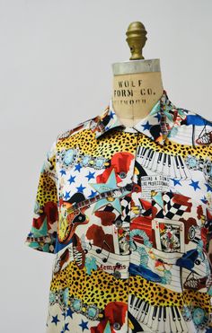 "Silk Elvis shirt by nicole miller Super fun conversational print (limited edition from the 1990's designed by one of the great designers, Nicole Miller. She's been known for her amazing dresses, and wild prints. * Gorgeous silk top * Elvis themed Memphis, blue suede shoes, hawaii, piano, guitar, record labels, the king!! Yes, Elvis was the king!! * Front picket * front button closure * extended removable shoulders Brand Nicole Miller Size Small 100% silk Great condition Sleeve length 8 1/2\" Bo Elvis Shirt, Vegas Vintage, Bust Form, Conversational Prints, Piano Guitar, Amazing Dresses, Blue Suede Shoes, Band Music, Sequin Jacket