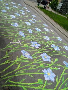 the sidewalk is painted with flowers and grass