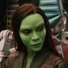 a woman with red hair and green makeup in a scene from the film, avengers