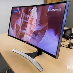 a computer monitor sitting on top of a wooden desk