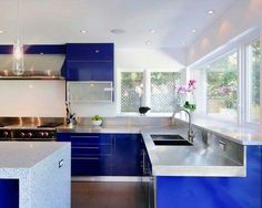 a modern kitchen with blue cabinets and stainless steel counter tops, along with an island in the middle