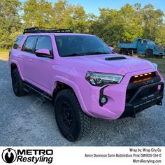 a pink toyota 4runner is parked on the gravel