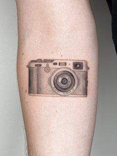 a camera tattoo on the right thigh is shown in black and white, it appears to be an old photo