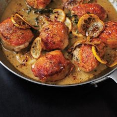 a pan filled with chicken and lemons on top of a table