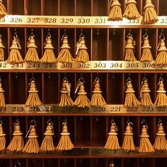 many bells are hanging on the wall in front of each other with numbers written on them