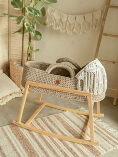 a baby's cradle in the corner of a room next to a potted plant