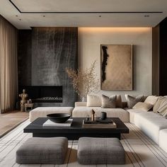 a modern living room with white couches and black coffee table in front of a painting on the wall