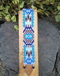 a piece of wood that has been beaded with blue and white designs on it