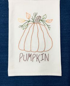 a white towel with a pumpkin embroidered on it's front and the words, pumpkin