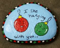 a painted rock that says i like having with you and two christmas ornaments on it