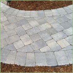 a brick walkway in the middle of a yard