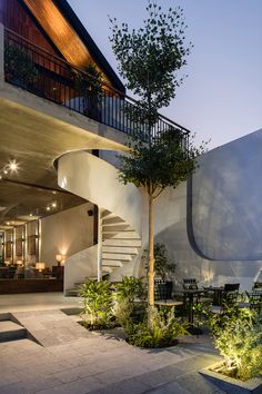 the outside of a house with stairs leading up to it's second floor and an outdoor dining area