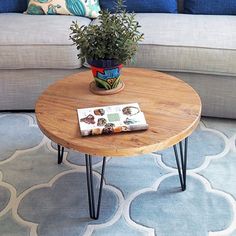 a wooden table with hairpin legs and a magazine on it in front of a couch