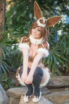 a woman in bunny ears sitting on top of a rock