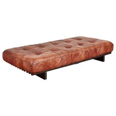 a brown leather bench sitting on top of a wooden frame