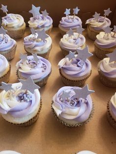 there are many cupcakes with purple frosting on the top and silver stars