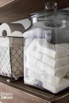 a glass jar filled with marshmallows sitting on top of a wooden shelf