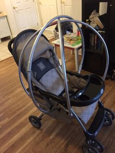 a baby stroller sitting on top of a hard wood floor