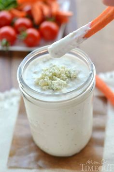 a carrot sticks sticking out of the top of a yogurt in a mason jar