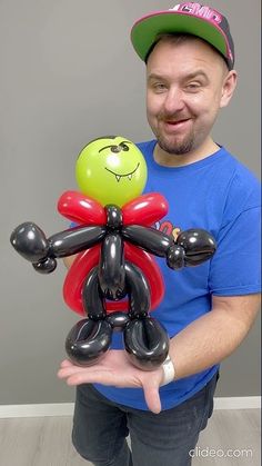 a man holding a balloon sculpture in his hands