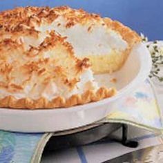 a pie sitting on top of a white plate next to a blue and white table cloth