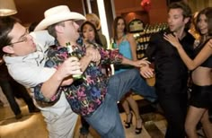 a man in a cowboy hat is dancing with other people