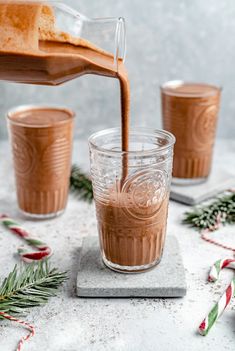 a glass filled with hot chocolate being poured into it