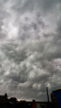 the sky is filled with dark clouds over buildings