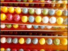 there are many different colored candies in plastic bags on the shelf, all lined up and ready to be eaten