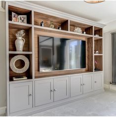 an entertainment center with built - in cabinets and a flat screen tv on the wall