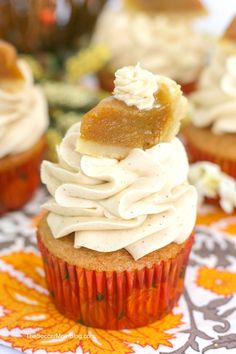 cupcakes with white frosting and caramel toppings on a fall tablecloth