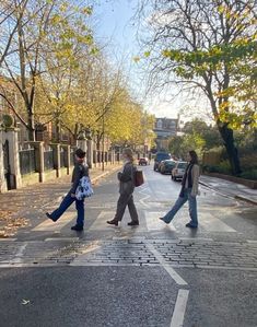 three people crossing the street at an intersection