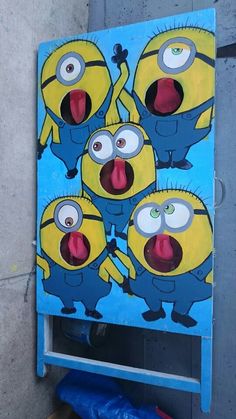 a painting of five minion faces on a blue background