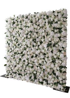 white flowers are arranged on the wall to create a backdrop for an event or party