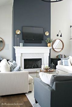 a living room filled with furniture and a flat screen tv mounted on the wall above a fireplace