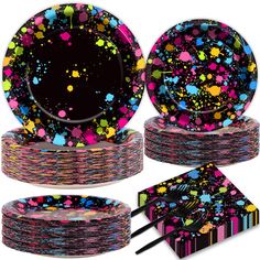 colorful party supplies including plates, napkins and placemats with splatter designs