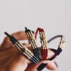 three bracelets are being held in the palm of someone's hand, with beads on them