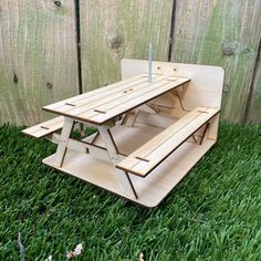 a wooden picnic table sitting in the grass