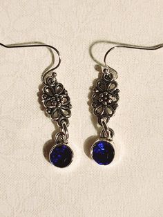 Pretty, silvery filigree charms have a deep blue gem hanging beneath each. Blue Gems, Flower Charm, Houston Tx, Deep Blue, Labour Day, Jewelry Earrings Dangle, Houston, Dangle Drop Earrings, Dangle Earrings