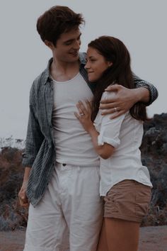 a man and woman embracing each other in the desert