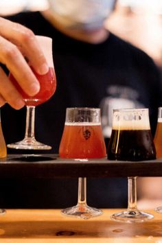 a tray with four different types of beer on it and a man in the background