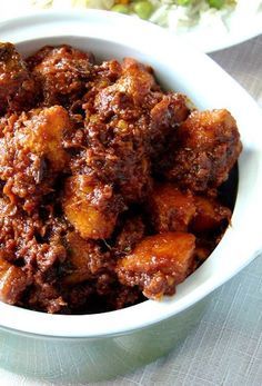 a white bowl filled with meat sitting on top of a table