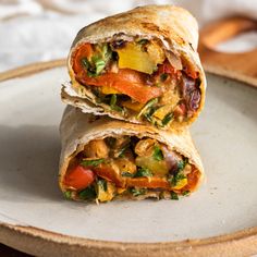 two burritos sitting on top of a white plate