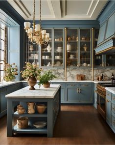 a large kitchen with blue cabinets and marble counter tops, an island in the middle