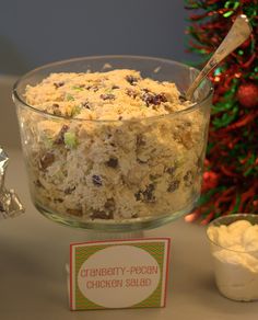 a glass bowl filled with food next to a christmas tree