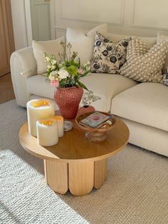 a living room filled with furniture and flowers on top of a table in front of a white couch